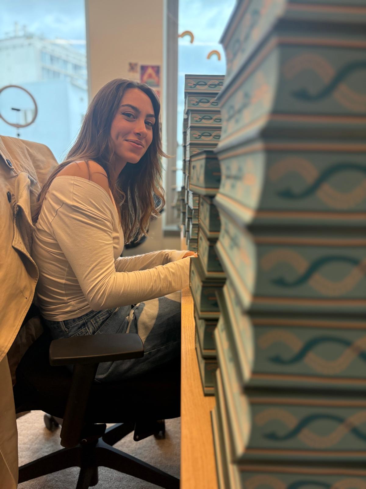 Cassandre Lambert avec une pile de livres à dédicacer