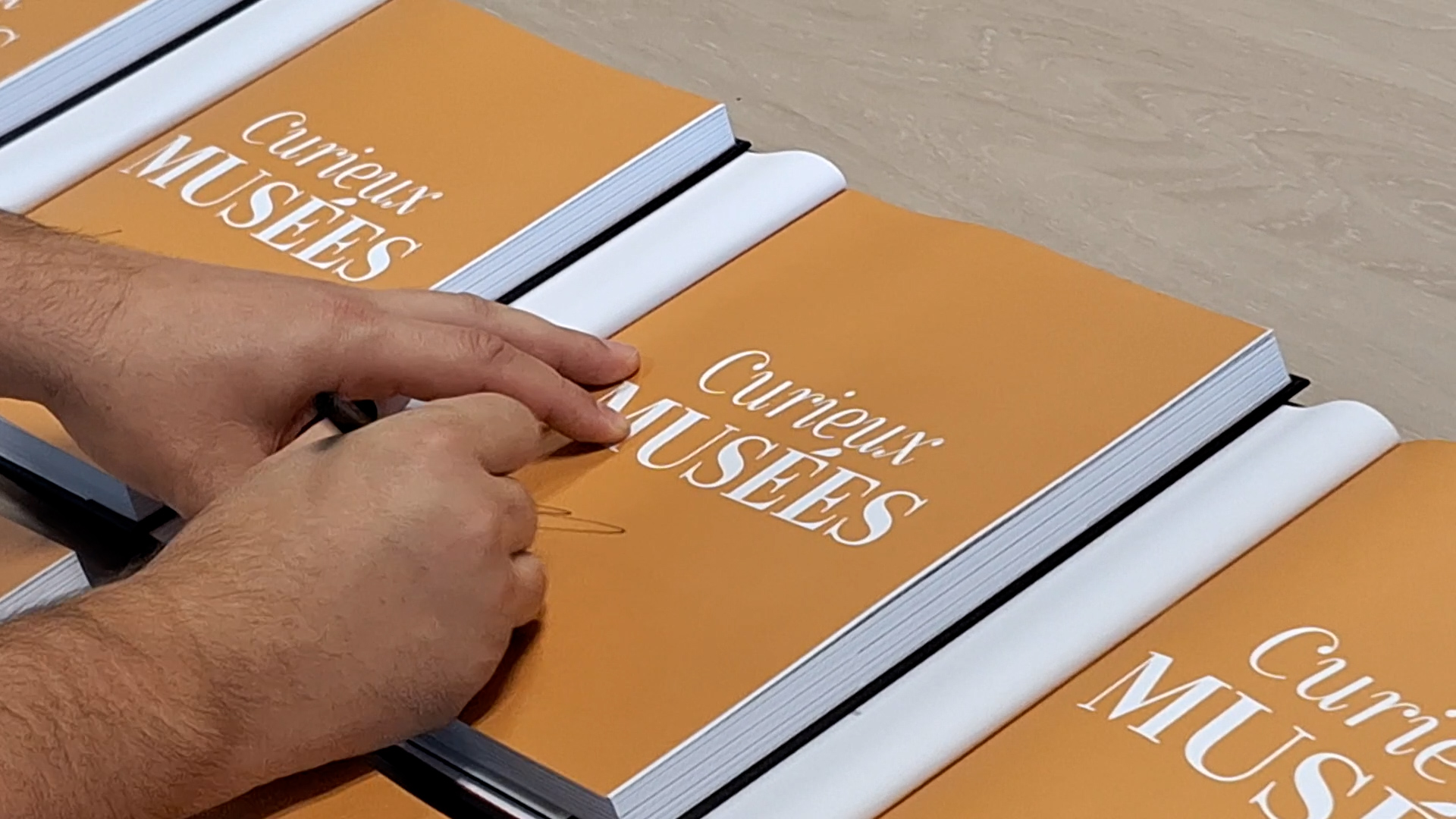 visuel de l'auteur en train de dédicacer le livre